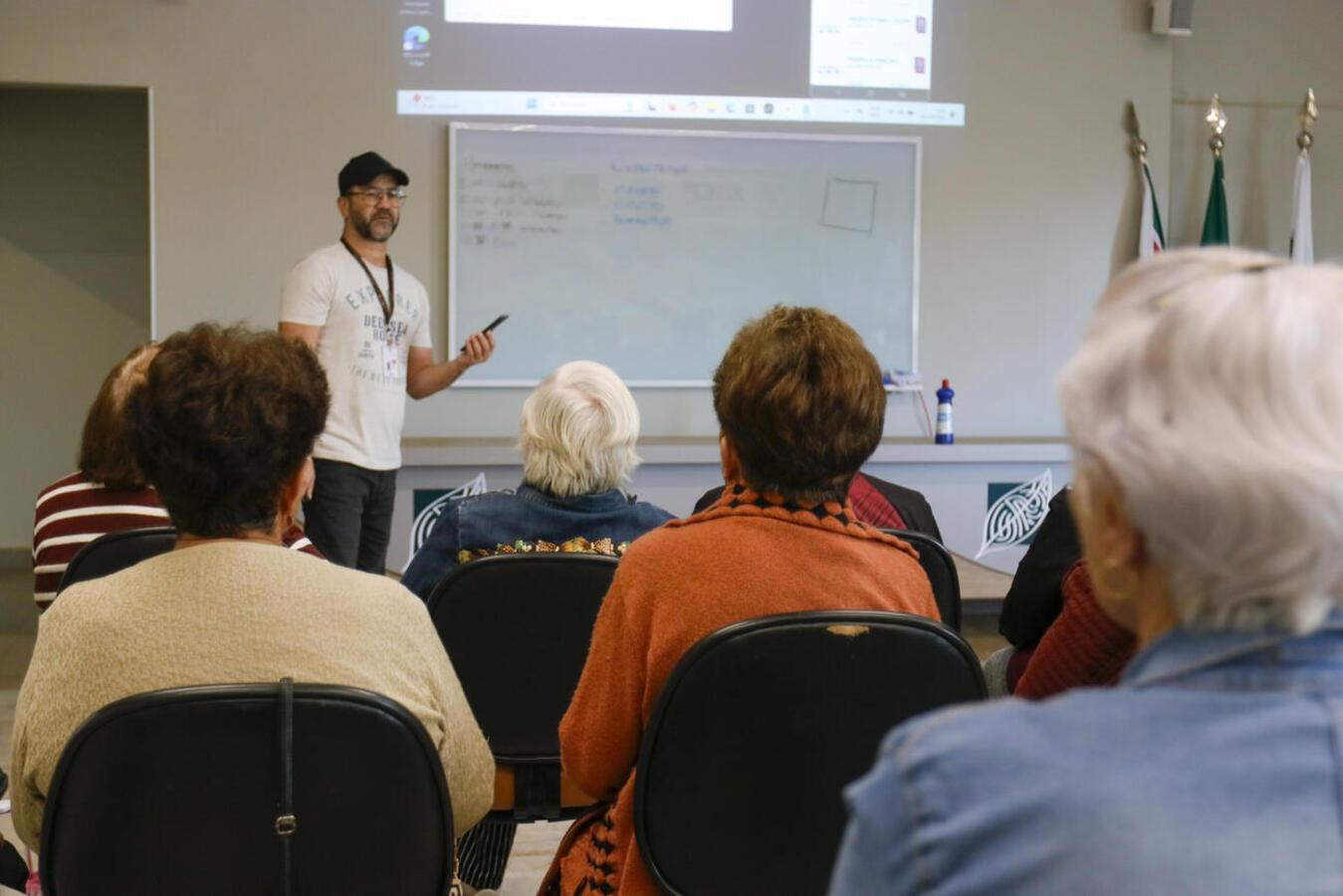 Adolescentes ajudam idosos em curso básico sobre o uso de smartphones